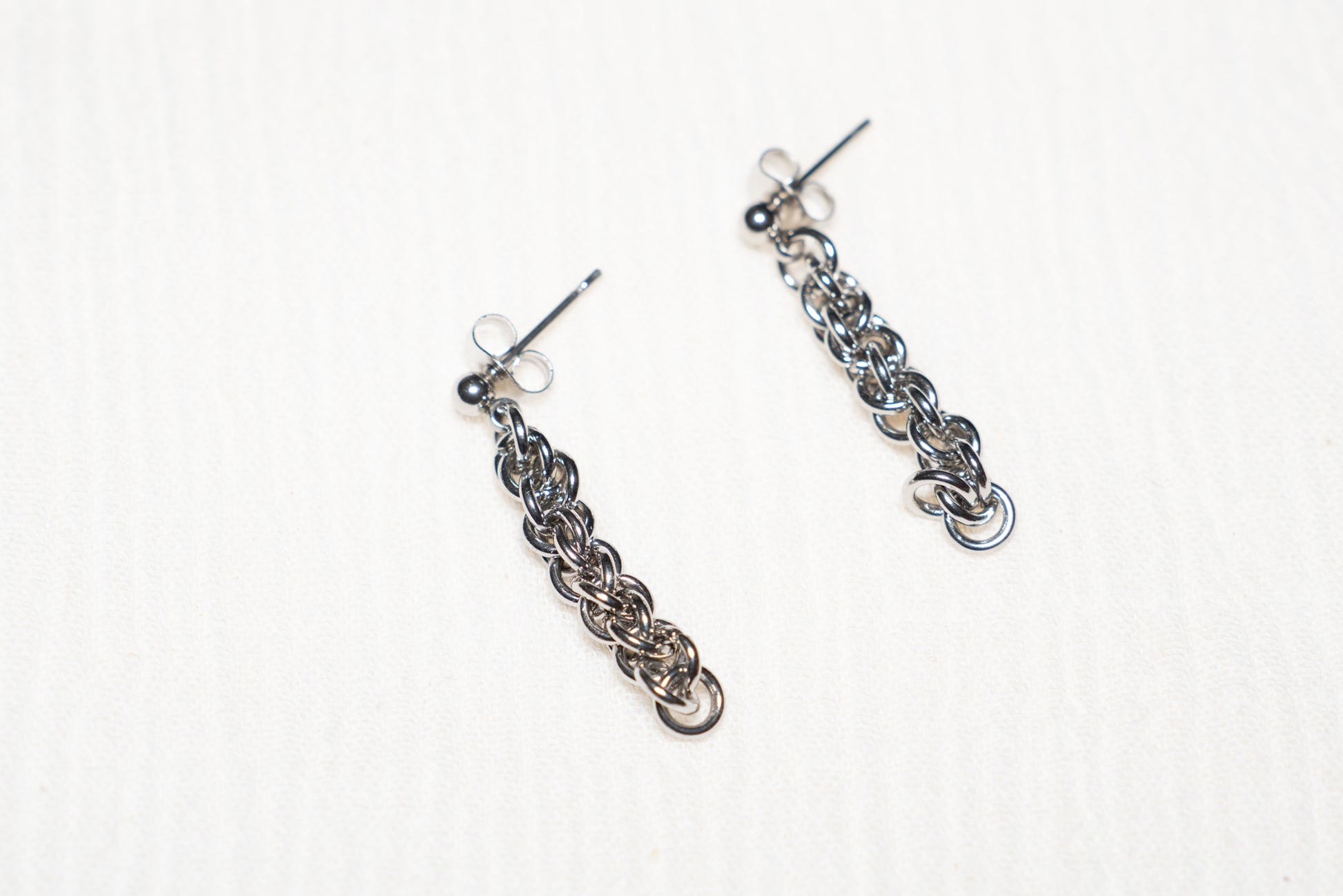 Silver tone chainlink earrings on a white background