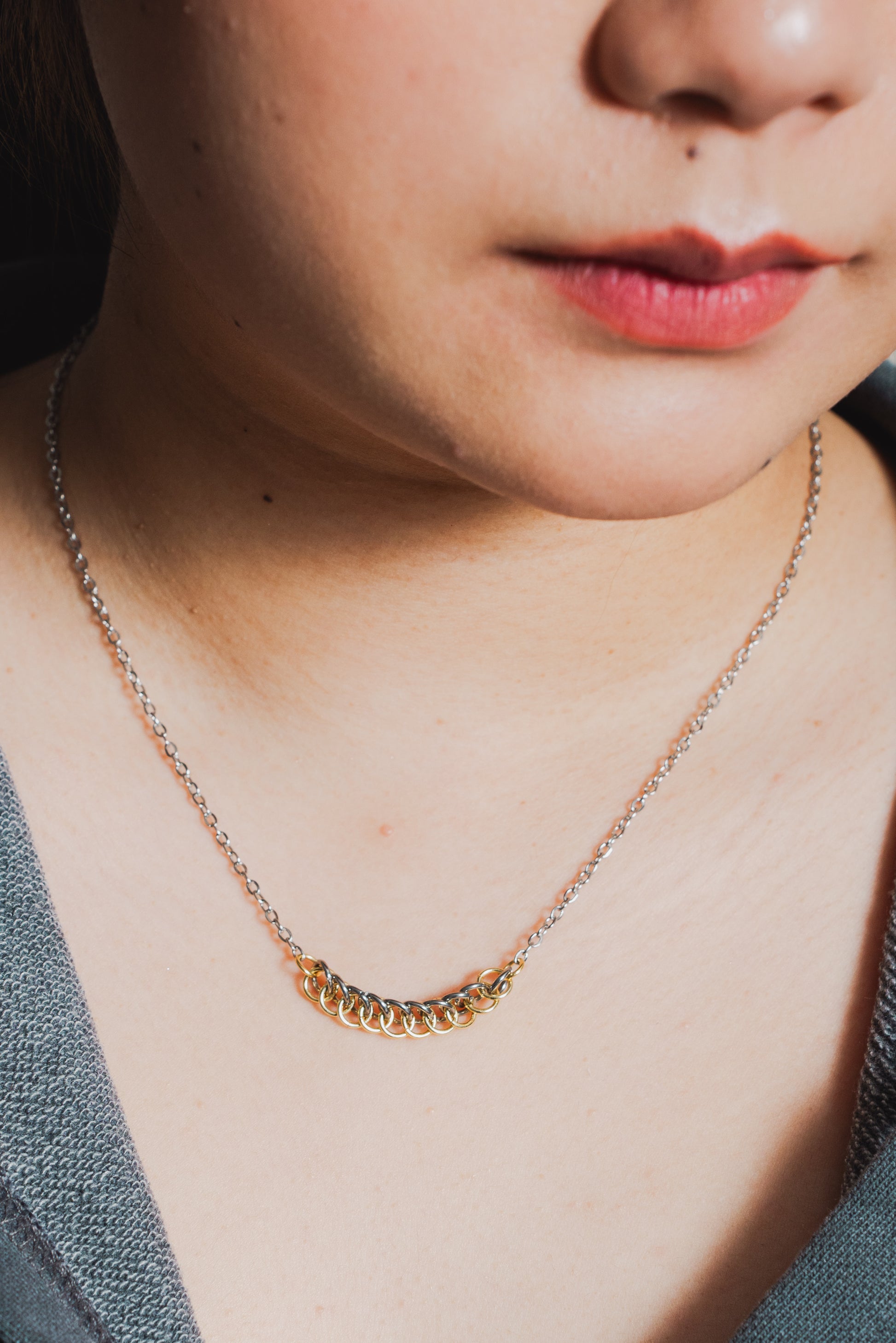 mixed metal gold and silver tone weave design with silver chain around female model's neck