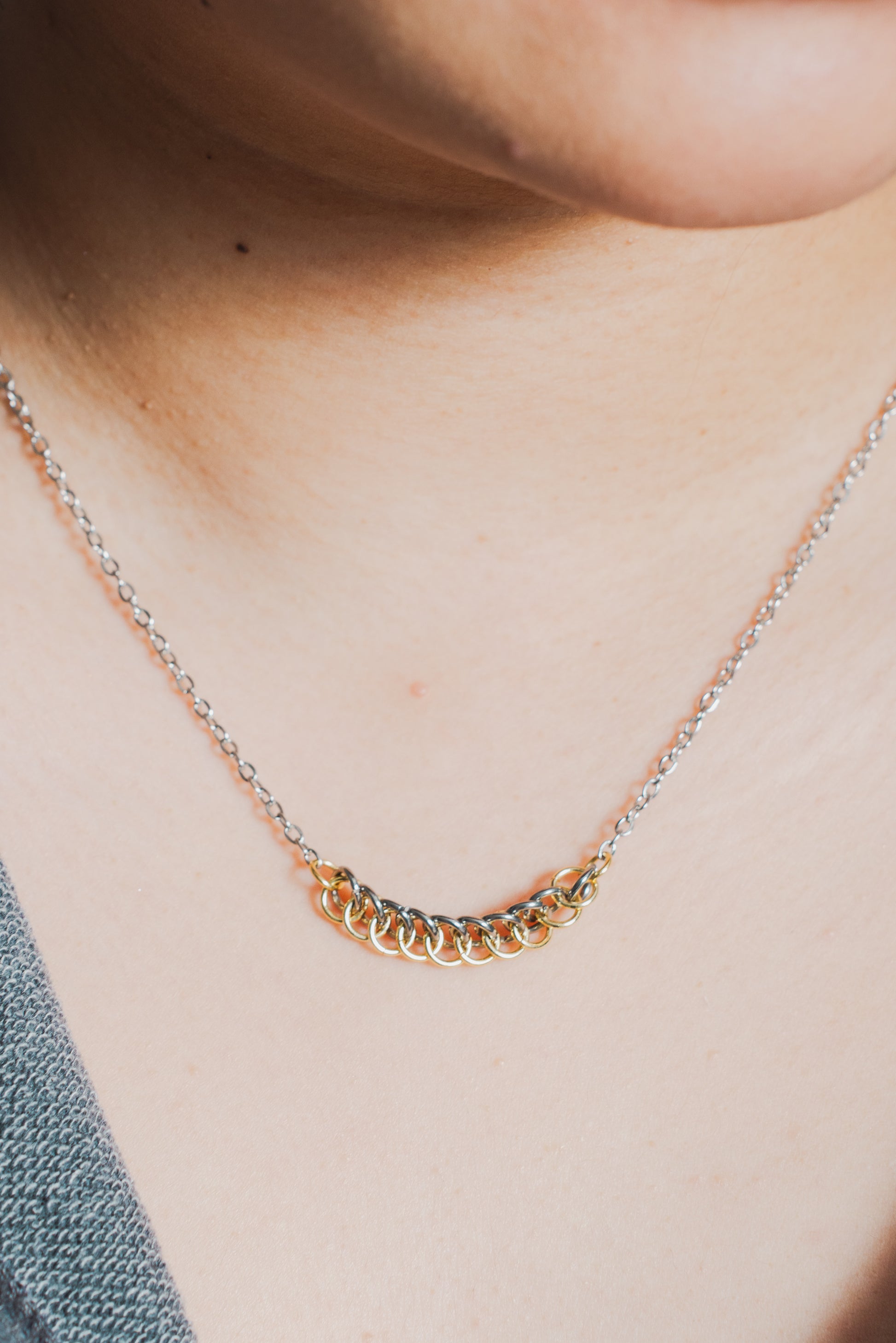 mixed metal gold and silver tone weave design with silver chain on model's neck